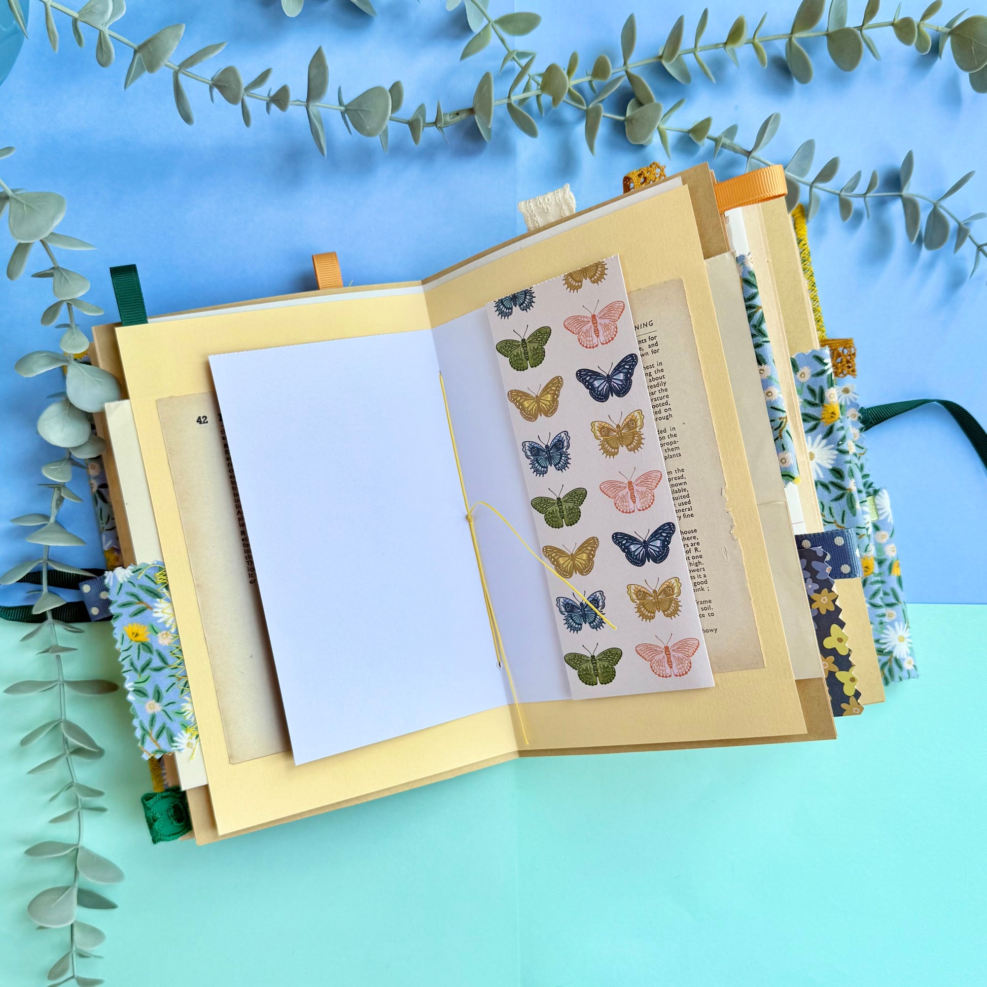 Open journal showing decorated pages with recycled and vintage papers