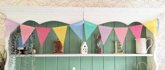 Reusable colourful fabric bunting with 12 pennants hanging across a space