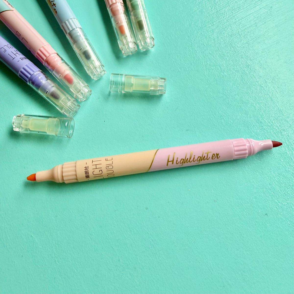 Pastel double-ended highlighter uncapped, showing orange & pink chisel tip